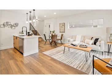 Open-concept living space with wood floors, stylish decor, and a modern staircase at 1344 N Knox Ct, Denver, CO 80204