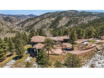 Luxury mountain home with tile roof, stone accents, and stunning views of the surrounding landscape at 290 Skyhill Dr, Evergreen, CO 80439