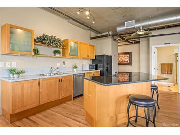 Modern kitchen with wood cabinets, granite countertops, and island at 1499 Blake St # 4O, Denver, CO 80202