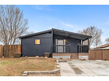 Charming single-story home boasts a covered porch and dark siding at 5523 Tejon St, Denver, CO 80221