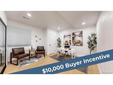 Bright home office featuring hardwood floors, modern decor, a white desk, and attractive art at 7932 E 49Th Pl, Denver, CO 80238