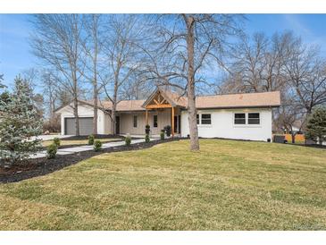 Inviting single-story home with a well-manicured lawn, pathway, and natural wood porch in a charming neighborhood at 5145 S Clarkson St, Greenwood Village, CO 80121