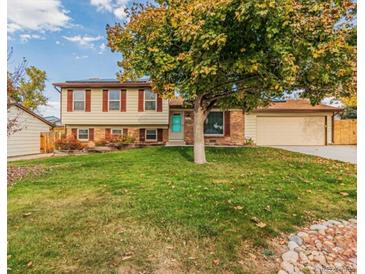 Charming two-story home with brick accents, a well-manicured lawn, and mature landscaping at 9510 Flower St, Broomfield, CO 80021