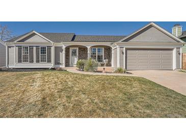 Charming ranch style home with stone accents, gray siding, and a well-maintained lawn at 21585 E Powers Cir, Centennial, CO 80015