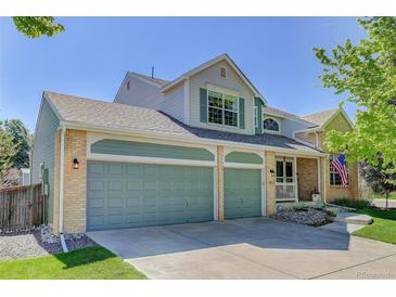 Charming home featuring a 3-car garage, manicured lawn, and inviting front porch at 15432 Greenstone Cir, Parker, CO 80134