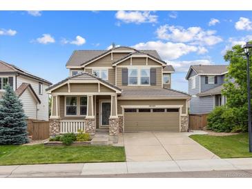 Charming two-story home boasts a landscaped yard, covered porch, and a two-car garage with ample parking space at 10535 Laurelglen Cir, Highlands Ranch, CO 80130