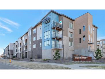 Modern condo building with balconies, brick accents, and professional landscaping at 400 E Fremont Pl # 207, Centennial, CO 80122