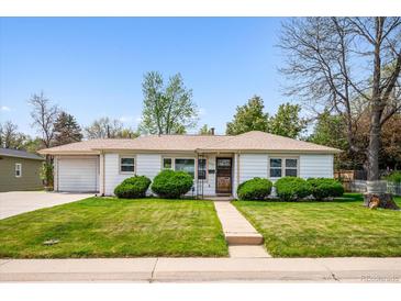 Charming single-story home with lush green lawn and manicured landscaping, with an attached one car garage at 8020 W 46Th Cir, Wheat Ridge, CO 80033