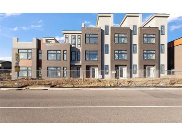 Modern townhomes featuring large windows, brick accents, and a contemporary design at 6959 E Lowry Blvd, Denver, CO 80230
