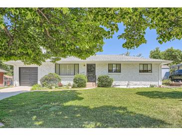 Charming brick home with a well-manicured lawn, established landscaping, and an attached garage at 366 Kenton St, Aurora, CO 80010
