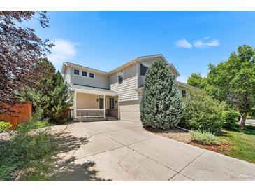 Inviting two-story home with a well-maintained lawn and a charming front porch at 11853 Trail View Ln, Parker, CO 80134