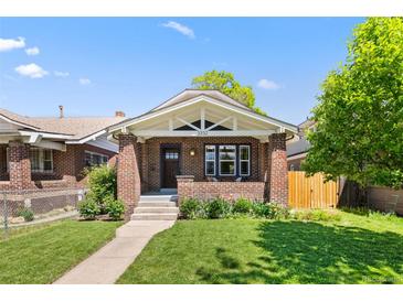 Charming brick home featuring a cozy front porch and well-maintained lawn on a sunny day at 3332 N Vine St, Denver, CO 80205