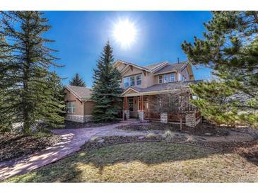 Beautiful home exterior with a well-manicured lawn, mature trees and a stone walkway at 3125 Starling Ct, Castle Rock, CO 80109