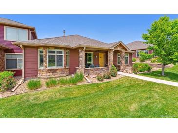 Charming exterior features a stone facade, lush landscaping, and a well-manicured lawn at 8595 Gold Peak Dr # A, Highlands Ranch, CO 80130