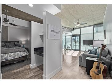 Open concept living room and bedroom with modern industrial finishes, and bright natural light at 1700 Bassett St # 820, Denver, CO 80202