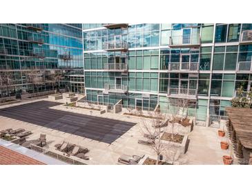 Rooftop pool deck and patio area with lounge chairs at modern condo building with glass facade at 1700 Bassett St # 820, Denver, CO 80202