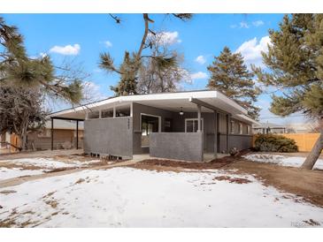 Stylish single-story home with a modern gray brick facade and covered porch, surrounded by a snowy landscape at 6087 S Elizabeth Way, Centennial, CO 80121