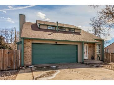 Charming home featuring a two-car garage, brick accents, dormer windows, and well-maintained landscaping at 6758 W Louisiana Pl, Lakewood, CO 80232