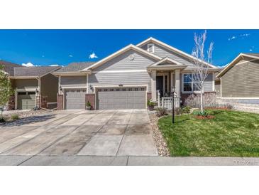 Charming home with a three-car garage, inviting entryway, and well-maintained lawn on a sunny day at 8054 E 152Nd Dr, Thornton, CO 80602
