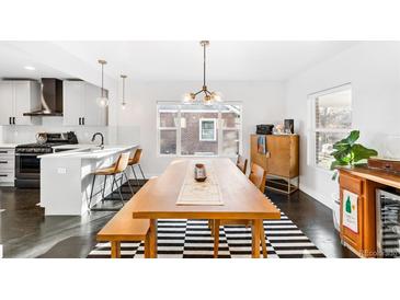 Bright dining room features dark wood floors, a modern light fixture, and a striped rug at 4270 Irving St, Denver, CO 80211