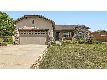 Charming single Gathering home featuring stone accents, a two-car garage, and a well-manicured lawn at 16550 Antero Cir, Broomfield, CO 80023