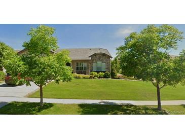 Charming single-story home featuring stone accents, a well-manicured lawn, and mature trees at 16550 Antero Cir, Broomfield, CO 80023