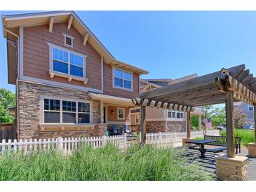 Inviting exterior view showcasing a two-story home with stone accents and outdoor dining area at 13713 Raritan Ln, Broomfield, CO 80023