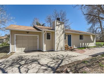 Charming single-story home with a chimney, attached garage, and a quaint blue front door at 6396 Twin Lakes Rd, Boulder, CO 80301
