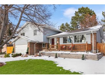 Two-story home with brick and siding, a wood deck, and a landscaped yard at 3346 S Quintero St, Aurora, CO 80013