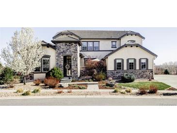 Stunning stucco and stone two-story home with a landscaped front yard and a welcoming entryway at 16791 W 48Th Ln, Golden, CO 80403