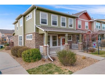 Charming two-story green home with stone accents and a welcoming front porch at 22813 E Briarwood Pl, Aurora, CO 80016
