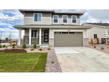 Charming two-story home with a two-car garage, well-manicured lawn, and inviting front porch at 24790 E 39Th Ave, Aurora, CO 80019