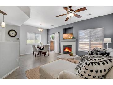 Bright living room features a cozy fireplace and an adjacent dining area, perfect for entertaining at 9080 Gale Blvd # 4, Thornton, CO 80260