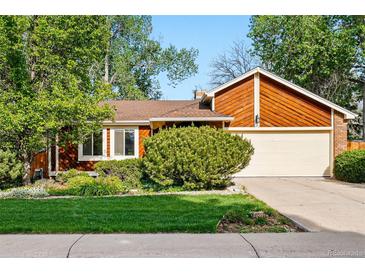Charming single-Gathering home featuring a manicured lawn, mature trees, and a two-car garage, perfect for suburban living at 7548 S Crocker Ct, Littleton, CO 80120