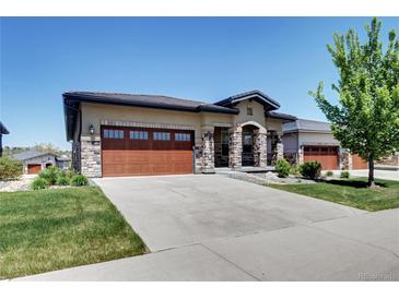 Charming home featuring stone accents, a spacious garage, and a well-manicured lawn at 365 Casalon Pl, Superior, CO 80027