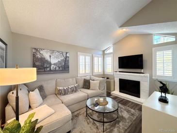 Bright living room with vaulted ceiling, fireplace, and comfortable seating at 4760 S Wadsworth Blvd # H207, Littleton, CO 80123