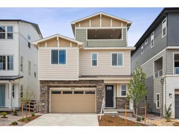 Beautiful multi-story home featuring mixed siding and stone accents, a two-car garage, and a covered patio at 8245 Butte Creek St, Littleton, CO 80125