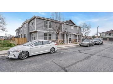 Exterior view of a multi-story townhome with gray siding and a well-maintained parking area at 17271 Waterhouse Cir # A, Parker, CO 80134