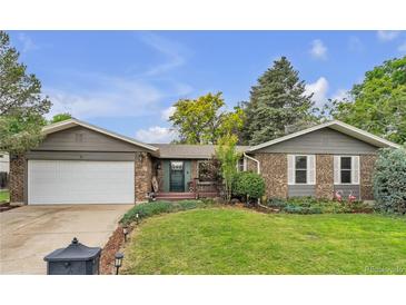 Charming brick home with a well-manicured front yard and an attached two-car garage at 3163 S Boston Ct, Denver, CO 80231