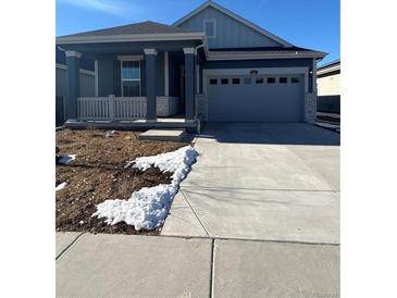 Ranch style home with gray exterior, attached garage, and landscaping at 5127 N Quemoy St, Aurora, CO 80019