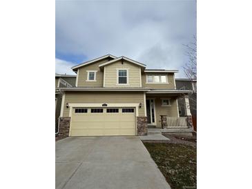 Charming two-story home with a two-car garage and manicured front lawn and covered porch at 10611 Casper St, Parker, CO 80134