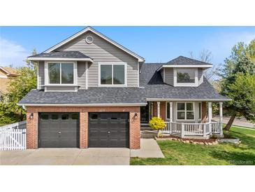 Charming two-story home showcasing a well-manicured lawn, brick accents, and an attached two-car garage at 3055 E 133Rd Cir, Thornton, CO 80241