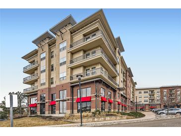Beautiful condominium building featuring brick and tan siding, multiple stories, and private balconies at 10111 Inverness Main St # 228, Englewood, CO 80112