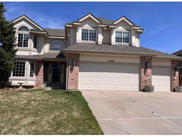 Charming two-story home featuring a three-car garage, brick accents, and well-manicured lawn at 11506 Greenbriar Ln, Parker, CO 80138
