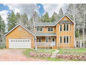Charming two-story home with a front porch, attached garage, and beautifully landscaped front yard at 13314 Spruce Creek Cir, Larkspur, CO 80118