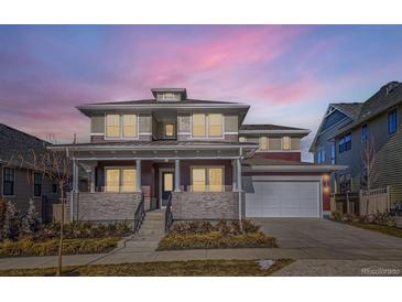 Stunning two-story home featuring a welcoming front porch, attached garage, and a beautifully landscaped yard at 1875 Hickory Ave, Erie, CO 80516