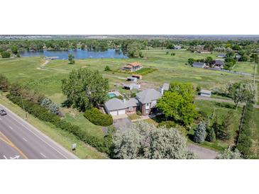 Sprawling estate with a charming home, a refreshing pool, and a serene lake backdrop at 14447 Madison St, Thornton, CO 80602