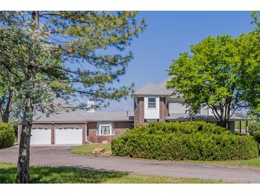 Charming two-story home featuring a brick facade, a two-car garage, and mature landscaping at 14447 Madison St, Thornton, CO 80602