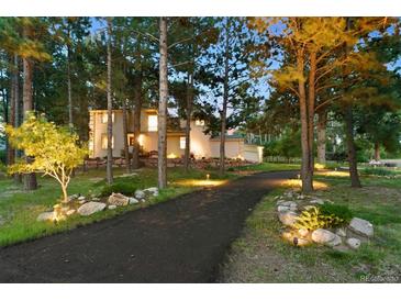 Inviting front of home with landscaped driveway and well-lit exterior at 18971 Shadowood Dr, Monument, CO 80132