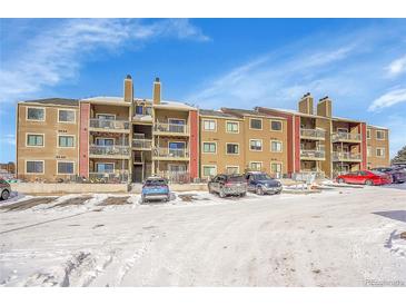 Tan multi-unit building with snow-covered parking lot at 10872 W Evans Ave # 2E, Lakewood, CO 80227